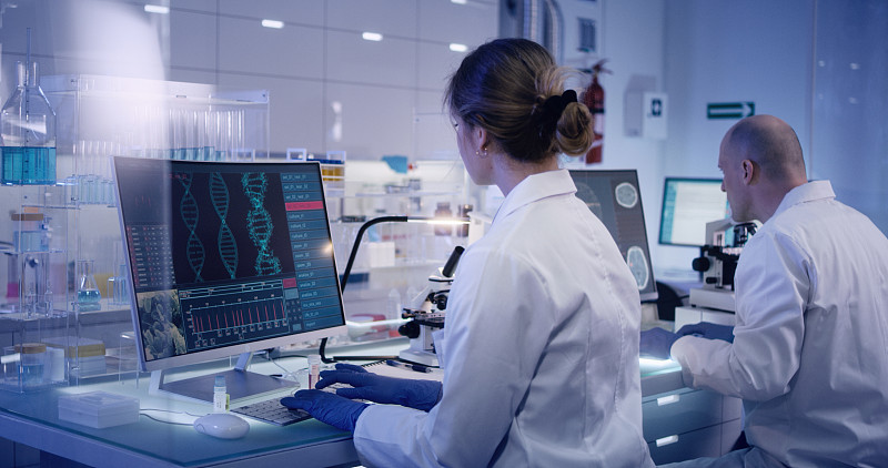 研究DNA突变的多民族研究小组。前景中的女医生图片下载