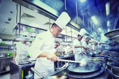 江南灶主厨侯新庆(左一)带领团队做菜。 受访者供图