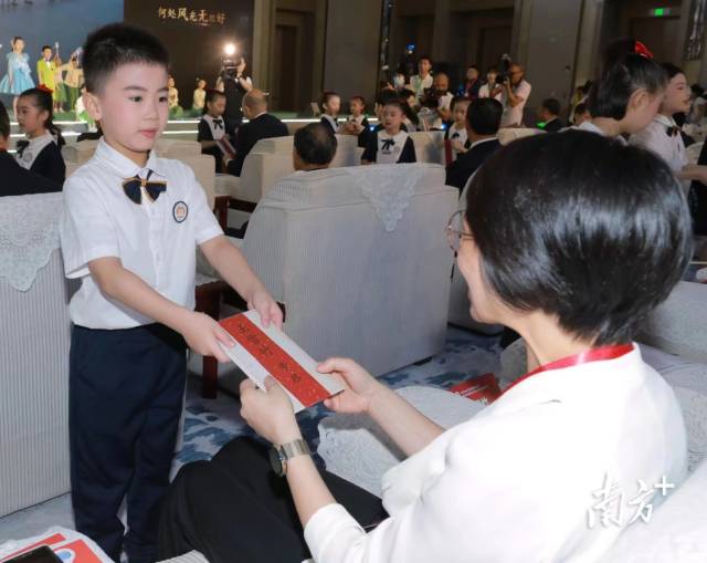 汕头小朋友为一位侨领递上“侨批邀约”。