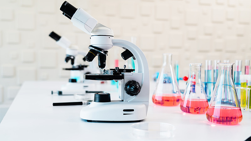 一排现代显微镜放置在大学科学教室或研究实验室的工作台上。科学教育、医学院培训或大规模临床诊断设施的概念。图片下载