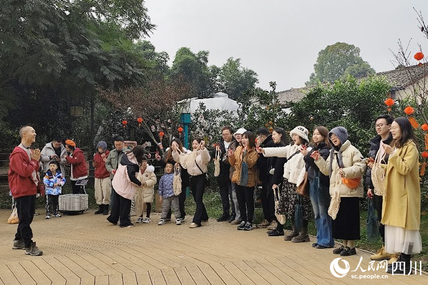 叶科（左一）给前来参与活动的“柑爸柑妈”介绍生态种植果。人民网记者朱虹摄